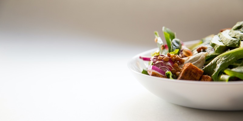 A white bowl filled with a fresh salad, set on a table for lunch at church.